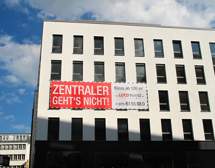 ImmobilienmarketingPVC Gitternetz / mesh. Temporäres Banner zum bewerben einer Immobilie. Montage ohne Bohrungen am Neubau. Der Stahlseilrahmen wurde mit Trägerklammern an den Fenstersimsen befestigt..